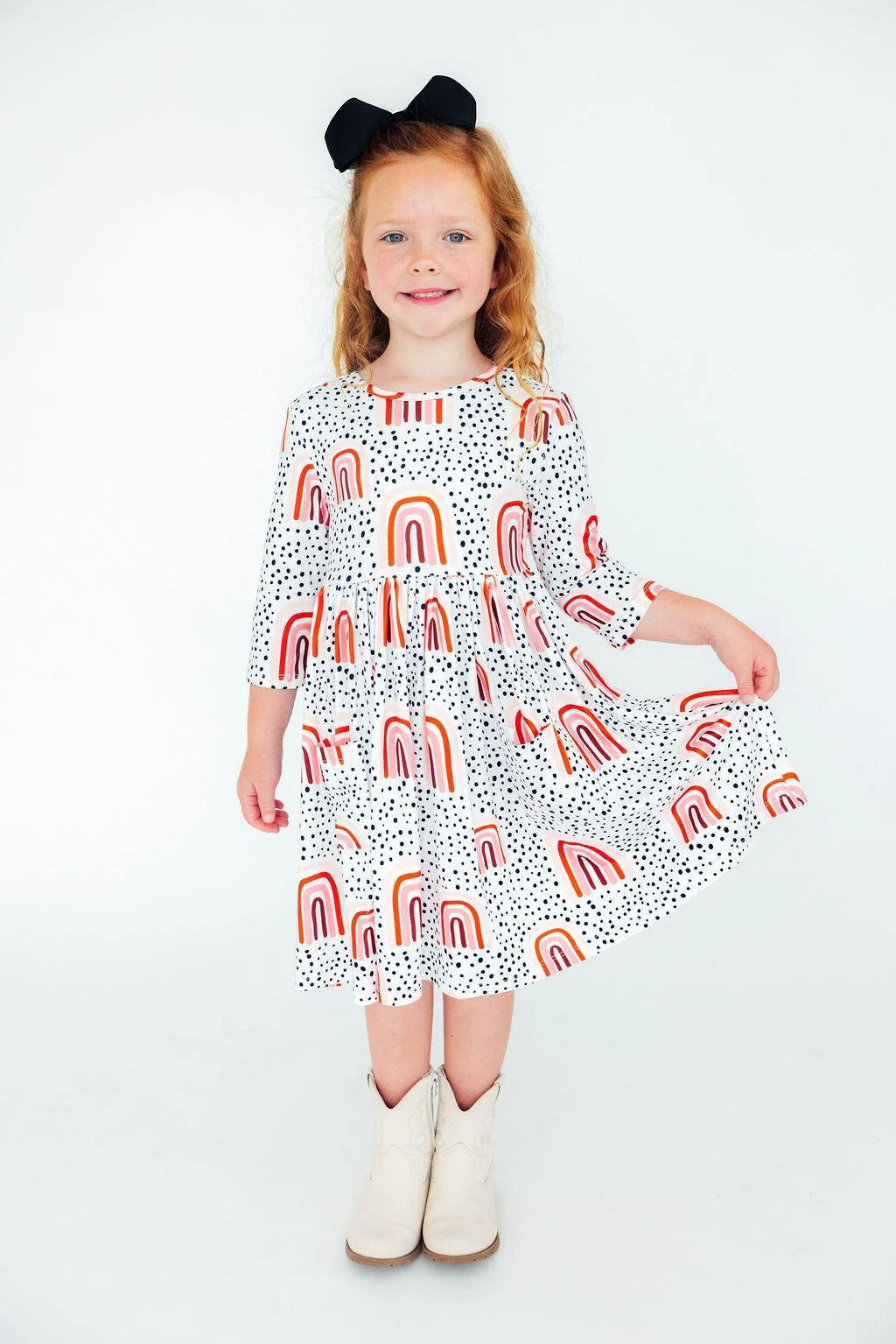 Girl wearing white dress with peach rainbows