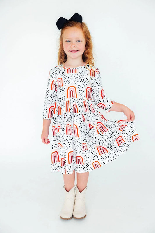 Girl wearing white dress with peach rainbows