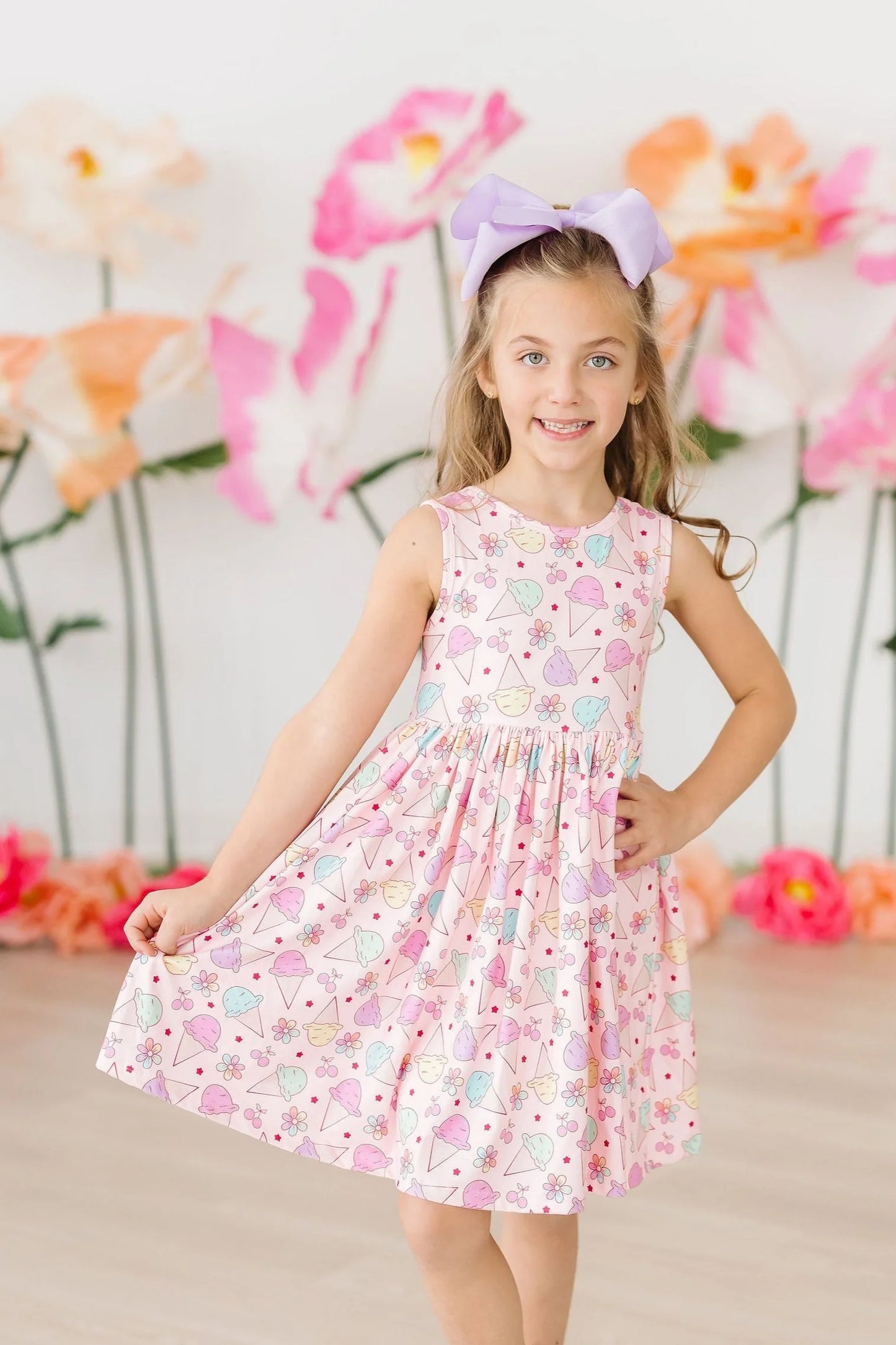 Girl wearing pink sleeveless twirl dress with colorful ice cream print