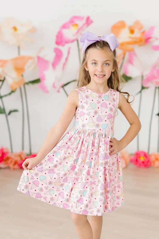 Girl wearing pink sleeveless twirl dress with colorful ice cream print
