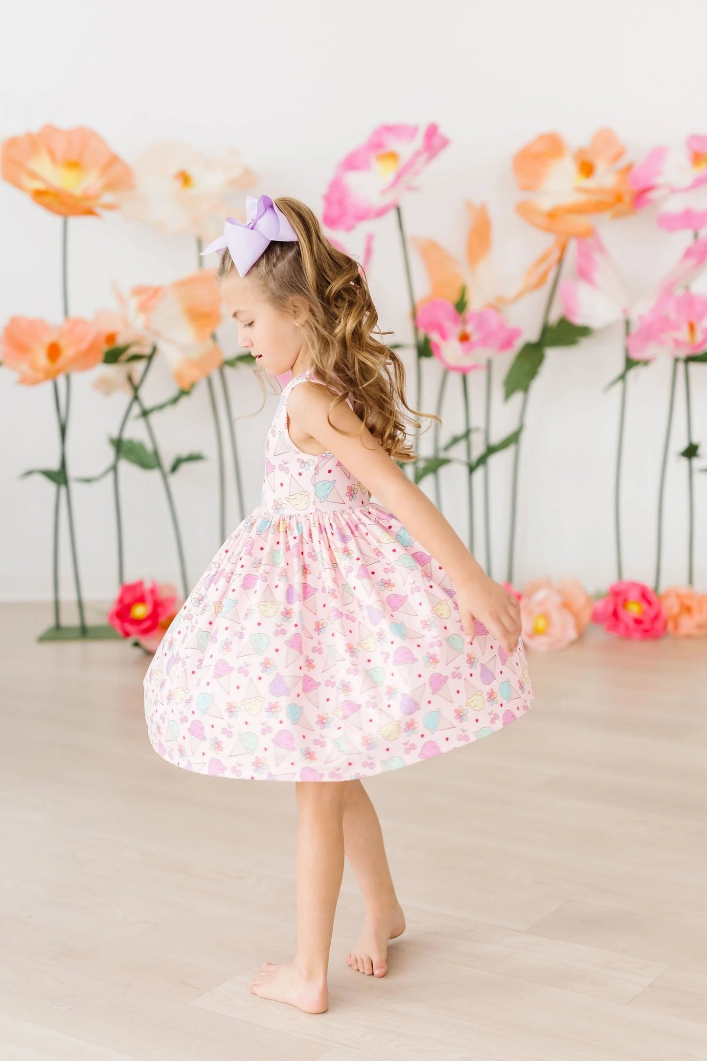 Girl wearing pink sleeveless twirl dress with colorful ice cream print
