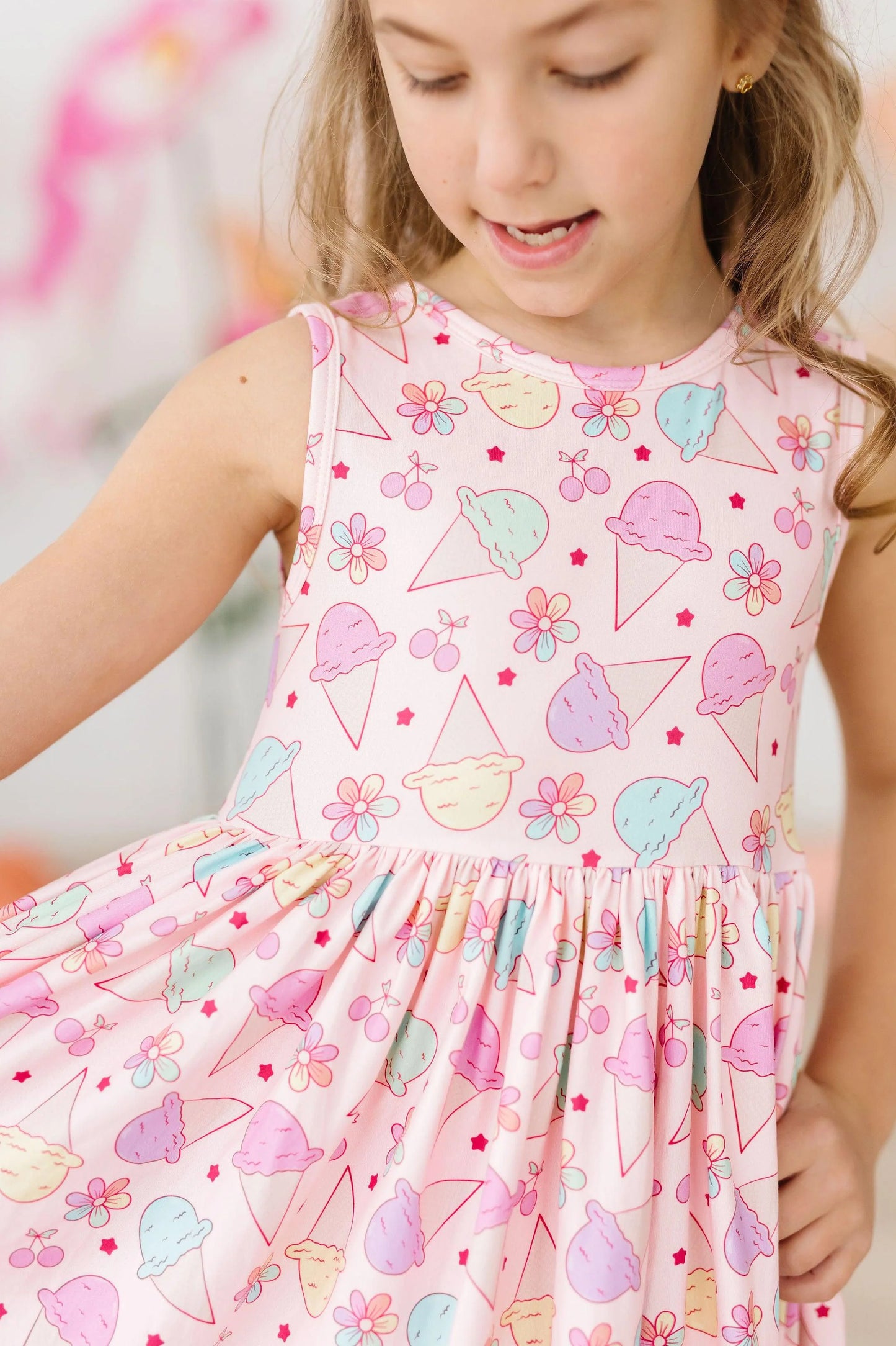 Girl wearing pink sleeveless twirl dress with colorful ice cream print